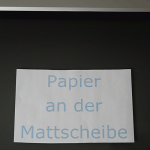 Foto zum Elektrostatik Experiment Papier klebt an der Bildröhre eines Fernsehers